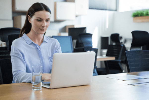qualificação de leads: imagem de uma mulher no escritório digitando em um notebook prata