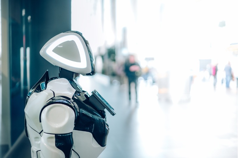 robo inteligencia artificial: imagem de um robô na cor branca e preta parado em um salão amplo