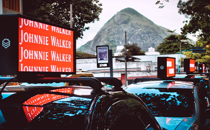 mobees: imagem de um anúncio da johnnie walker no carro da mobees no trânsito do rio de janeiro