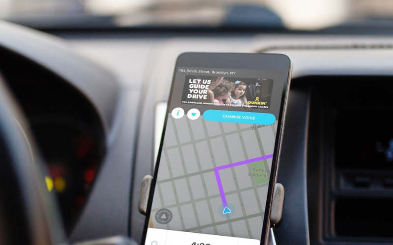 waze ads: imagem de um celular dentro do carro com o aplicativo waze aberto na tela exibindo um anúncio