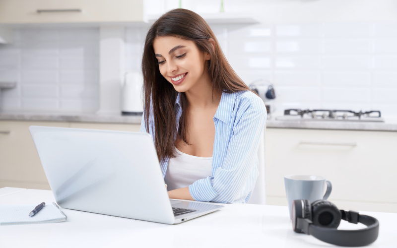 YouTube Ads: mulher sorrindo, vestida com uma camisa azul claro e olhando para o computador.