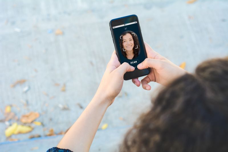Deep Learning: imagem de uma mulher fazendo o reconhecimento facial em seu smarthphone.